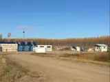 Road with blue garbage bins in background